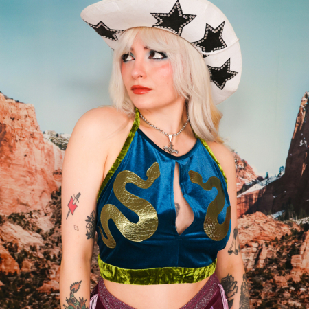 blonde woman in a teal halter top and cowboy hat
